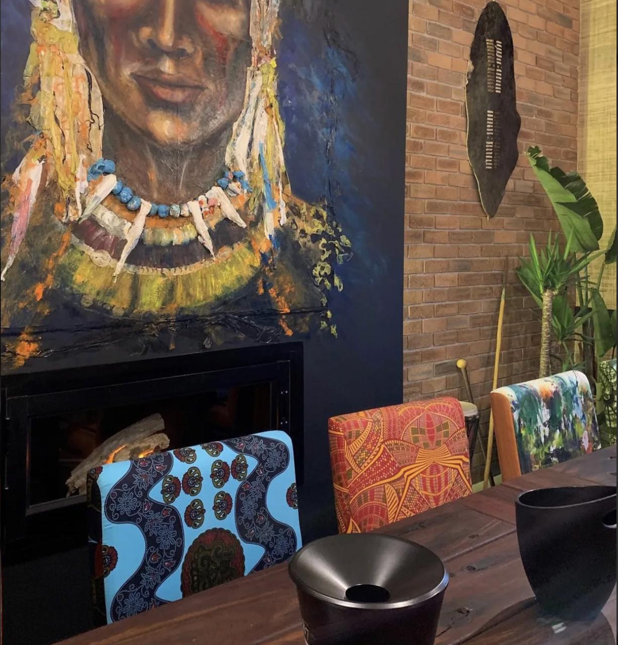 Seventeen87 Wine Cellar close-up of the portrait mural, brick wall, and patterned upholstery