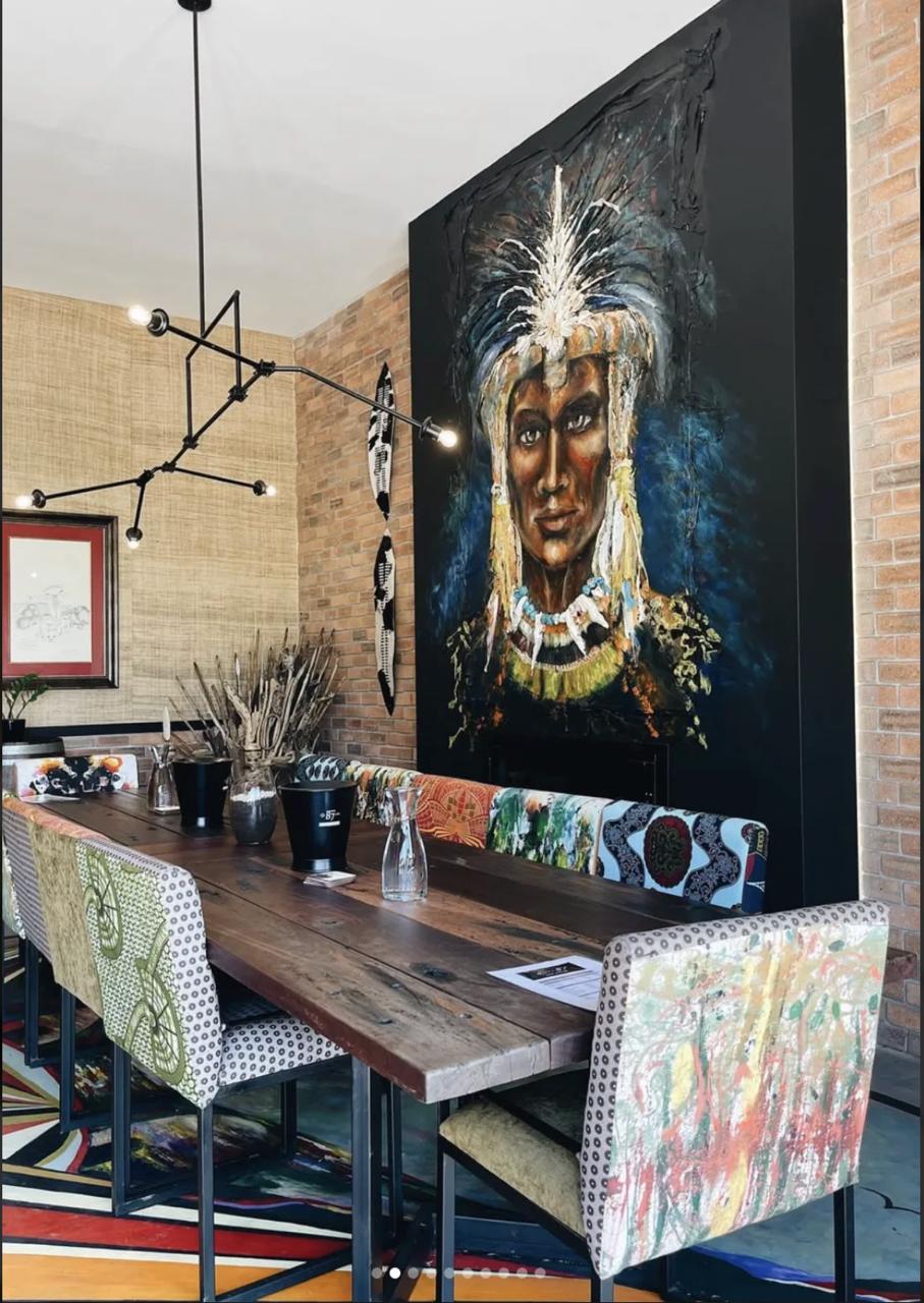 Seventeen87 Wine Cellar tasting table framed by the feature mural and patterned dining chairs