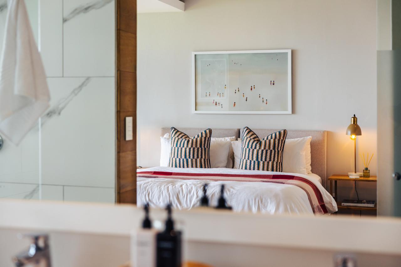 Whitefoord Beach House bedroom seen through the bathroom