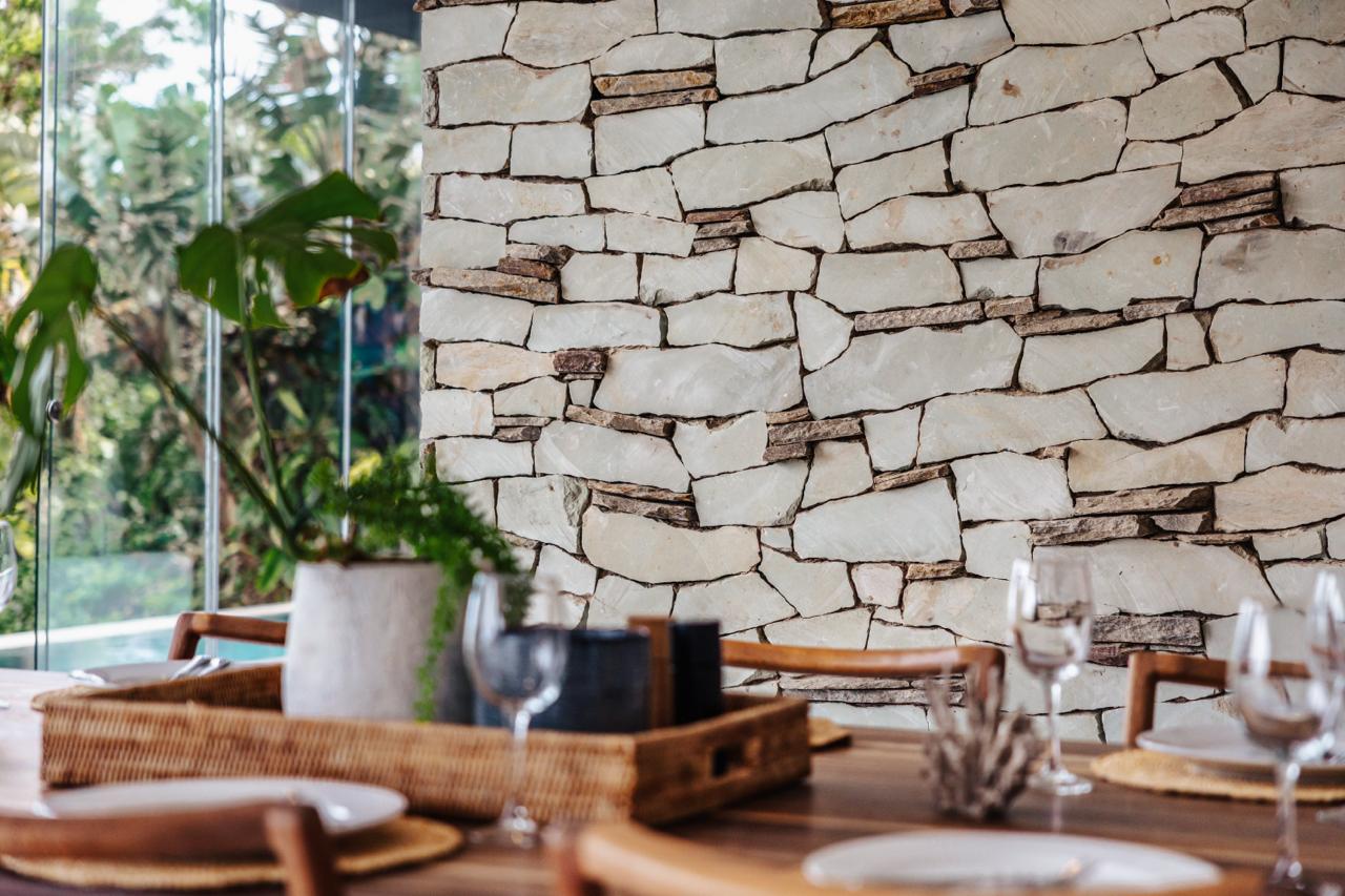 Whitefoord Beach House dining area with textured stone wall